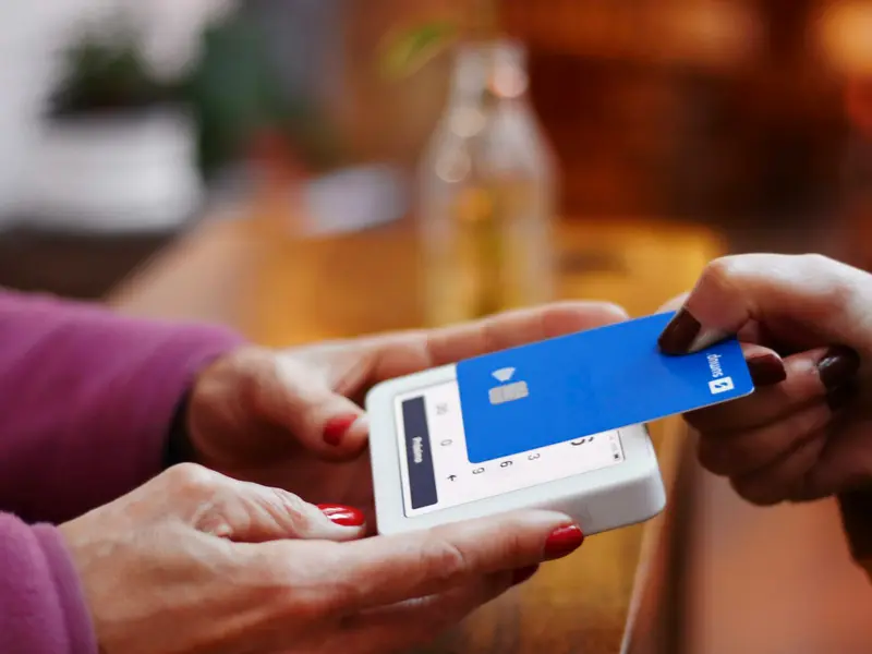 A card held next to a payment terminal at a counter